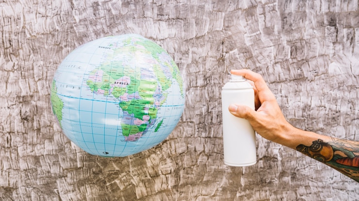 Zdarma Fotografie human hand holding bottle near globe over wooden background