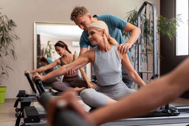 people in pilates reformer class exercising their bodies