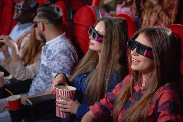 pretty teenagers enjoying comedy in cinema