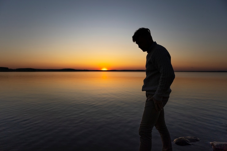 Zdarma Fotografie sad and contemplative person near lake