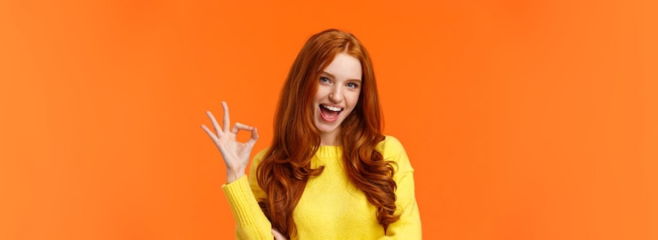 Zdarma Fotografie sassy and daring cool redhead girl with curls showing okay excellent gesture and smiling excited ass