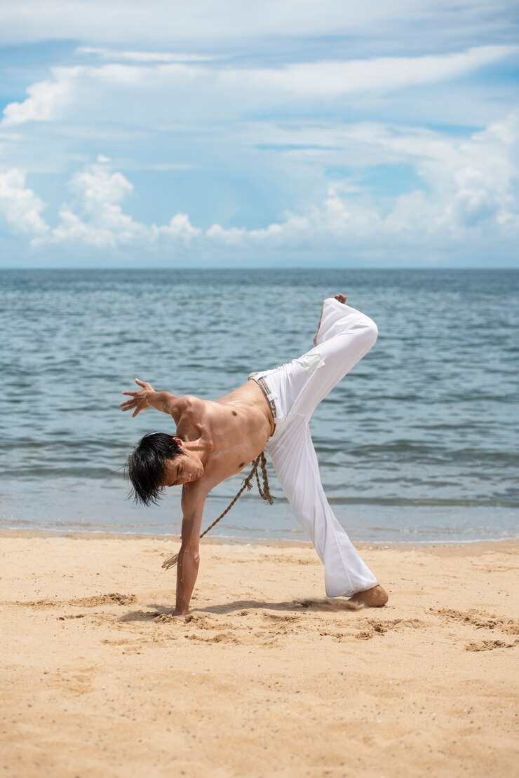 Zdarma Fotografie shirtless man practicing capoeira by himself on the beach