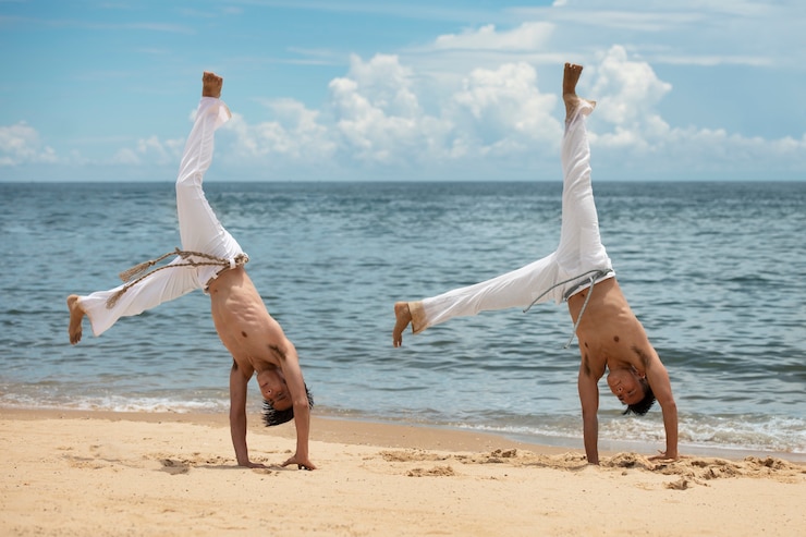 Zdarma Fotografie shirtless men practicing capoeira on the beach