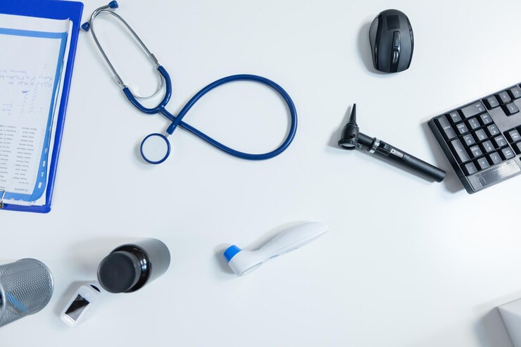 Zdarma Fotografie top view of medical examination tools standing on table in empty modern doctor office ready for health care consultation. hospital workplace equipped with professional instruments. medicine support
