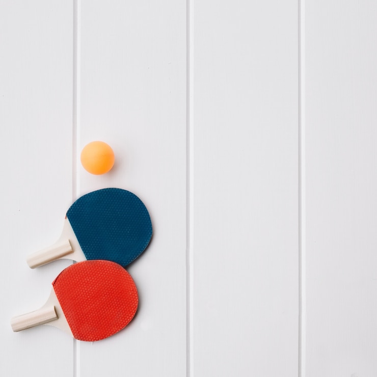 Zdarma Fotografie two ping pong racket and ball over white wood background with space