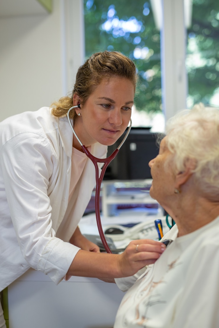 Zdarma Fotografie vertical shot of a female doctor listening to an elderly heartbeat