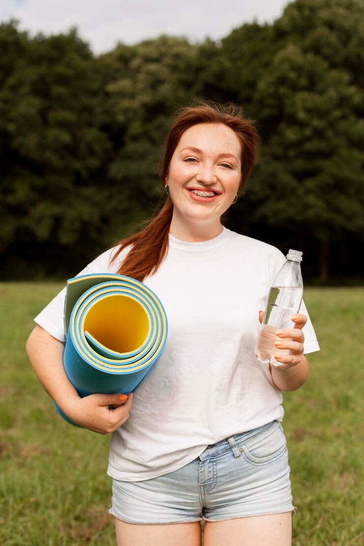 Zdarma Fotografie woman holding water bottle and yoga mat outdoors
