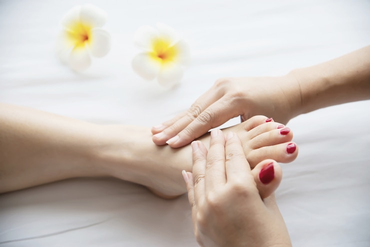 Zdarma Fotografie woman receiving foot massage service from masseuse close up at hand and foot - relax in foot massage therapy service concept