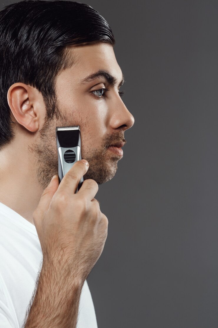 Zdarma Fotografie young handsome man shaving over grey wall