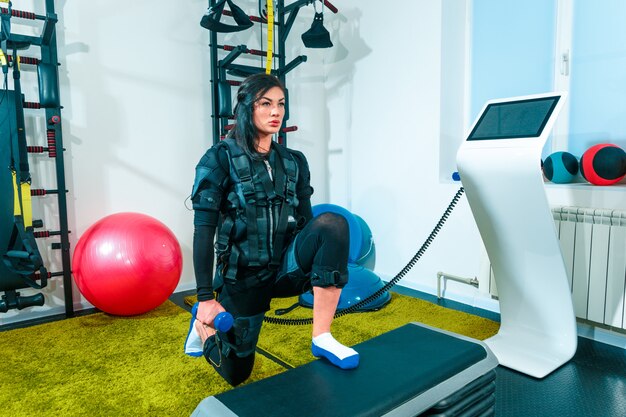 A atleta feminina que eles exercitam em um estúdio de fitness ems