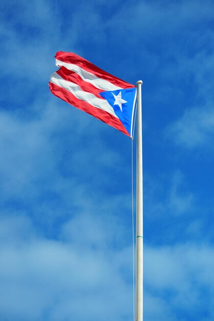 A bandeira do estado de Porto Rico voa com céu azul em San Juan.