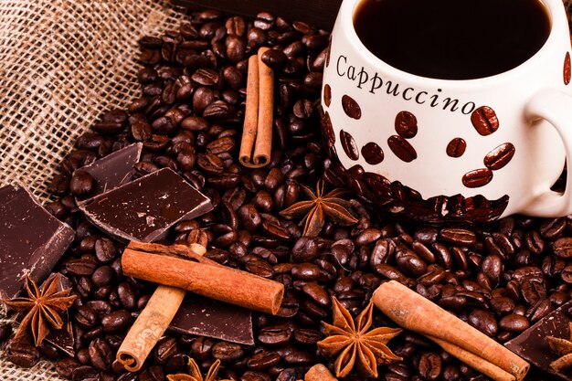 A canela e outras espécies estão em grãos de café antes de uma xícara