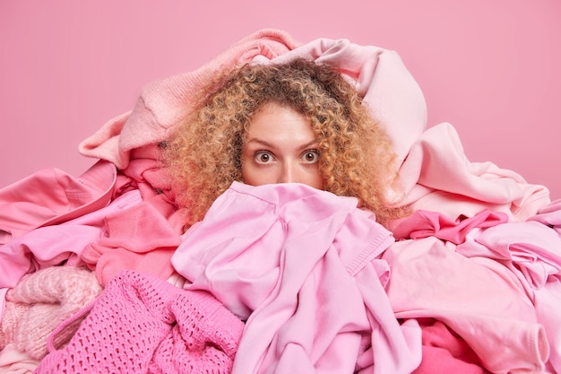 A cena interna de uma mulher em choque cercada por roupas cor-de-rosa ajuda as pessoas com roupas doadas, enquanto obras de caridade escolhem roupas para uso secundário ou reciclagem.