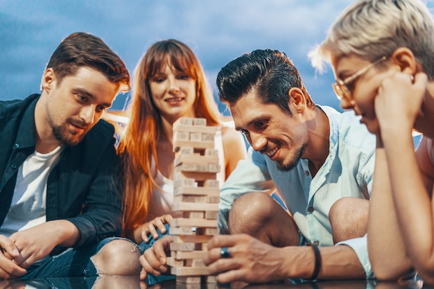 A companhia de jovens jogando jogo de tabuleiro