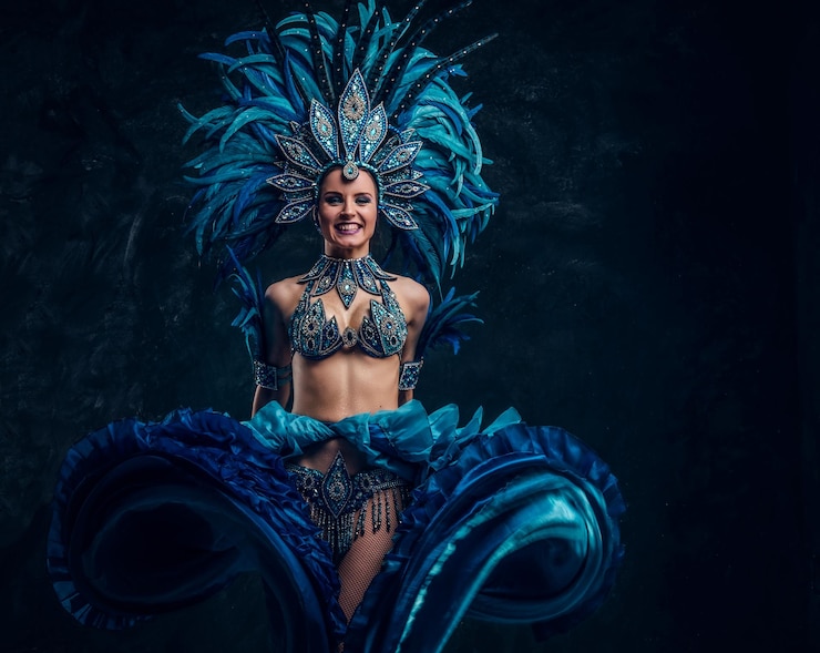 Foto grátis a dançarina de lata sorridente festiva em traje azul está mostrando seu desempenho.
