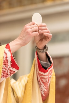 A elevação do pão sacramental durante a liturgia católica