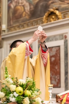 A elevação do pão sacramental durante a liturgia católica