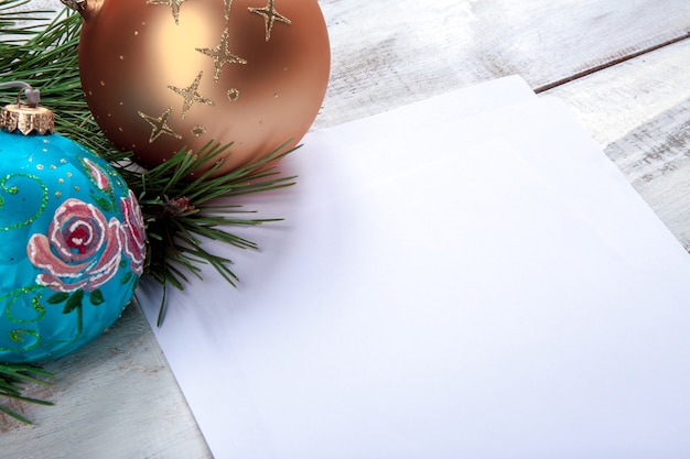 A folha de papel em branco na mesa de madeira com enfeites de Natal.