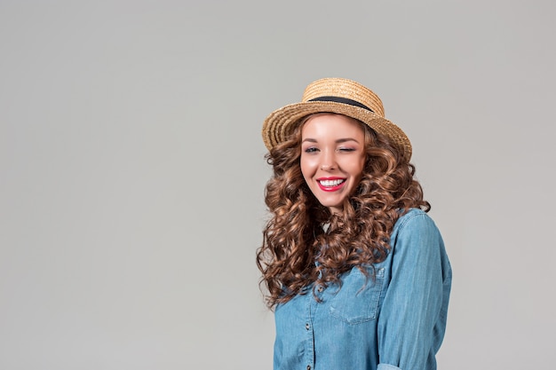 Foto grátis a garota com chapéu de palha na parede cinza