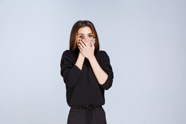 A garota de camisa preta parece emocionada e assustada. Foto de alta qualidade