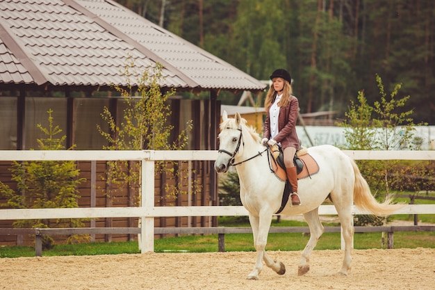 A garota monta um cavalo