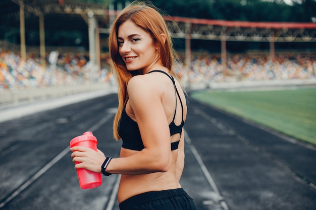 A garota no estádio está praticando esportes