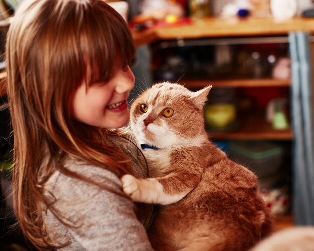 A garota ruiva mantém o gato ruivo