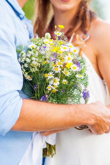 A imagem da colheita do casal romântico com flores