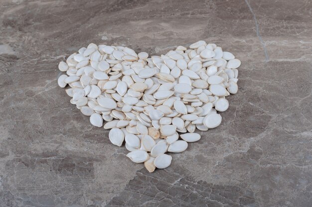 A imagem de um coração feito de sementes na superfície do mármore