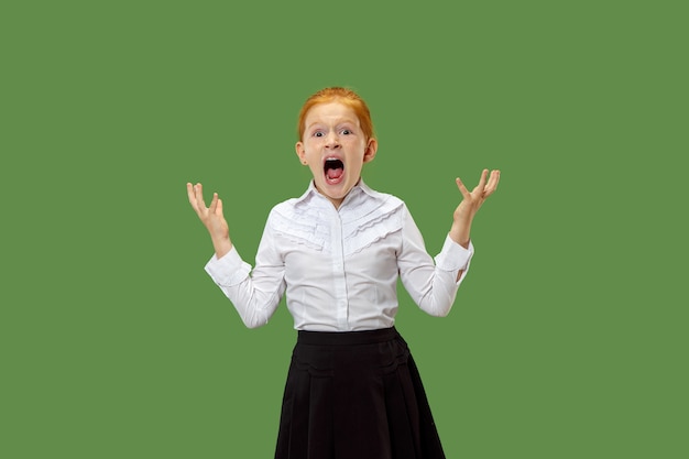 Foto grátis a jovem adolescente com raiva emocional gritando no fundo verde do estúdio