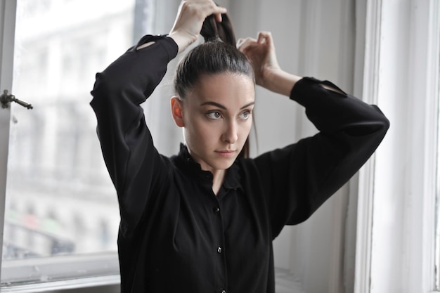 A jovem coloca o cabelo para trás