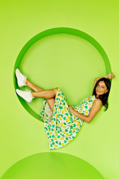 Foto grátis a jovem esbelta bronzeada louca com sorriso branco de neve está descansando no fundo verde mulher bonita com está se divertindo durante a sessão de fotos conceito de beleza feminina de estilo de vida