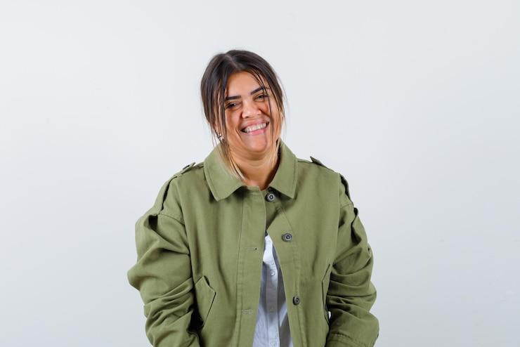 Foto grátis a jovem está olhando para a câmera com um sorriso no fundo branco