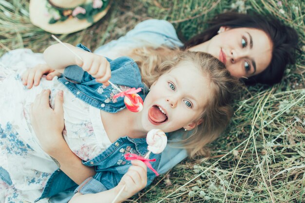 A jovem mãe e filha no espaço de grama verde