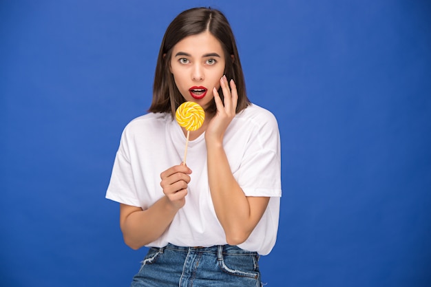 A jovem mulher com pirulito colorido