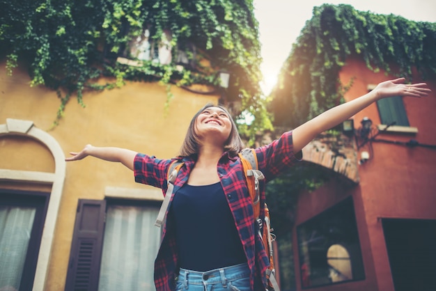 A jovem mulher feliz aprecia o curso que levanta suas mãos em urbano. conceito de estilo de vida de mulher.