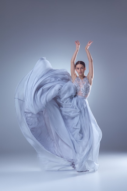 A linda bailarina dançando em um vestido longo lilás com fundo lilás