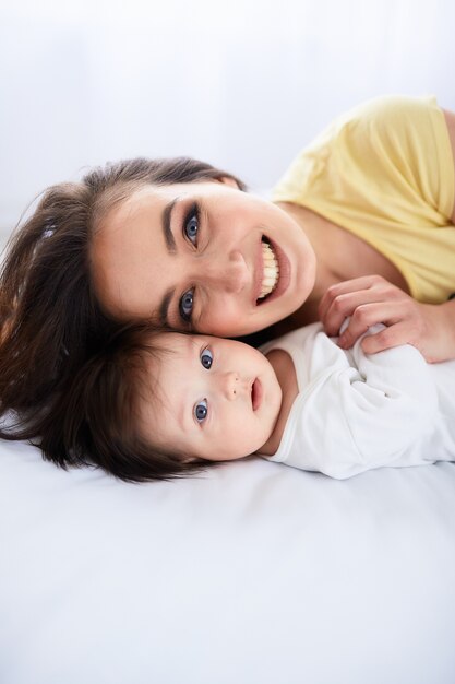 A mãe abraça a filha e fica deitada na cama