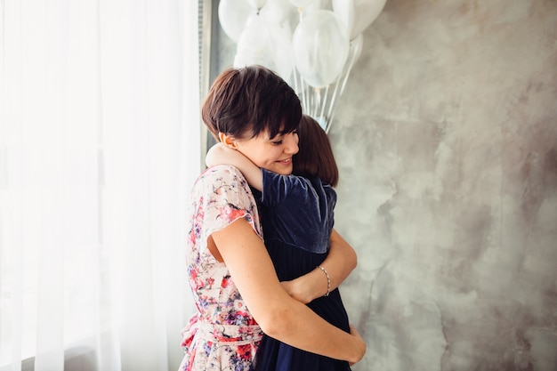 A mãe abraçando sua filha no quarto