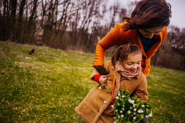 A mãe com filha andando pelo parque