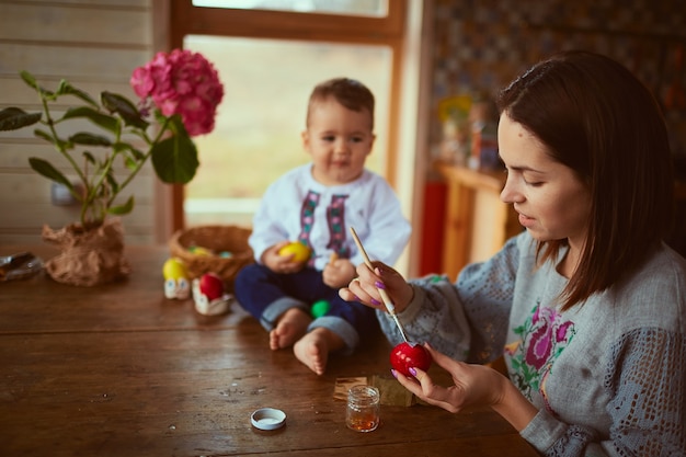 A mãe e filho pintando ovos de páscoa