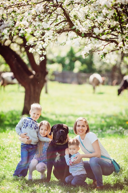 A mãe, filhos e cachorro sentado na grama