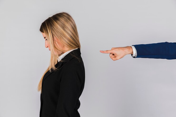 Foto grátis a mão de um empresário culpando a jovem empresária contra o pano de fundo cinzento