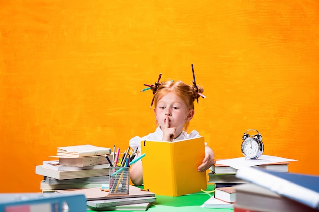 A menina adolescente ruiva com muitos livros em casa.