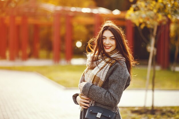 A menina anda. Mulher com um casaco. Morena com um lenço.