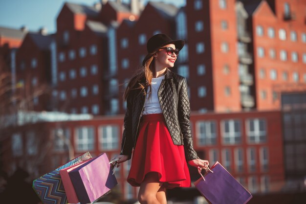 A menina andando com as compras nas ruas da cidade