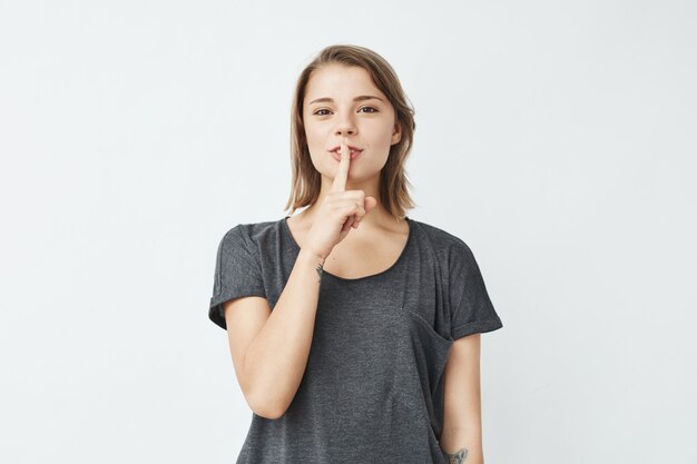 A menina bonita nova na exibição cinzenta do t-shirt mantém o silêncio.