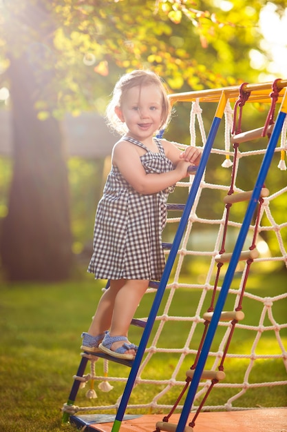A menina brincando no playground ao ar livre