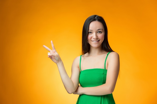 A menina chinesa feliz no espaço amarelo