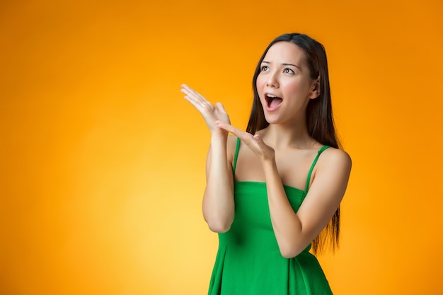 A menina chinesa surpresa em fundo amarelo